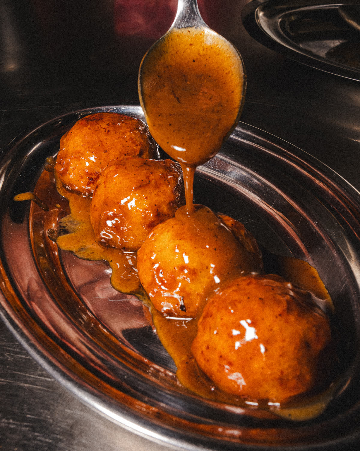 polpette glassate con la salsa versata al cucchiaio